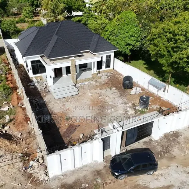 A White Compound House Roofed With Classic Euro Roofing Tiles · Photo 1