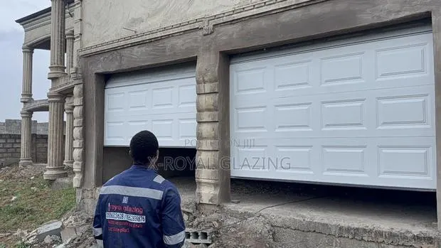 White Modern Remote Double Garage Door Well Installed · Photo 1