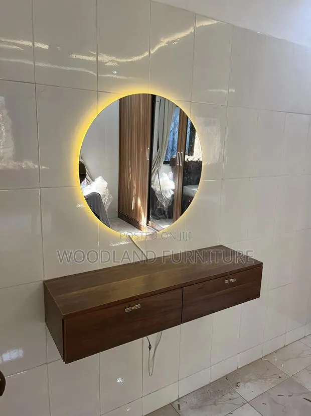 A Floating Walnut Vanity With a Warm Light Round Mirror Clean Lines · Photo 1