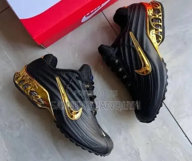 A Black Nike Sneaker With a Glossy Upper and a Metallic Gold Swoosh · Photo 1