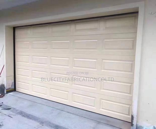 Sectional Garage Door With Automatic Motor and Remote · Photo 1