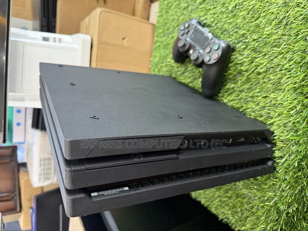 Playstation 4 Pro Console Display With One Controller and One Cd · Photo 3