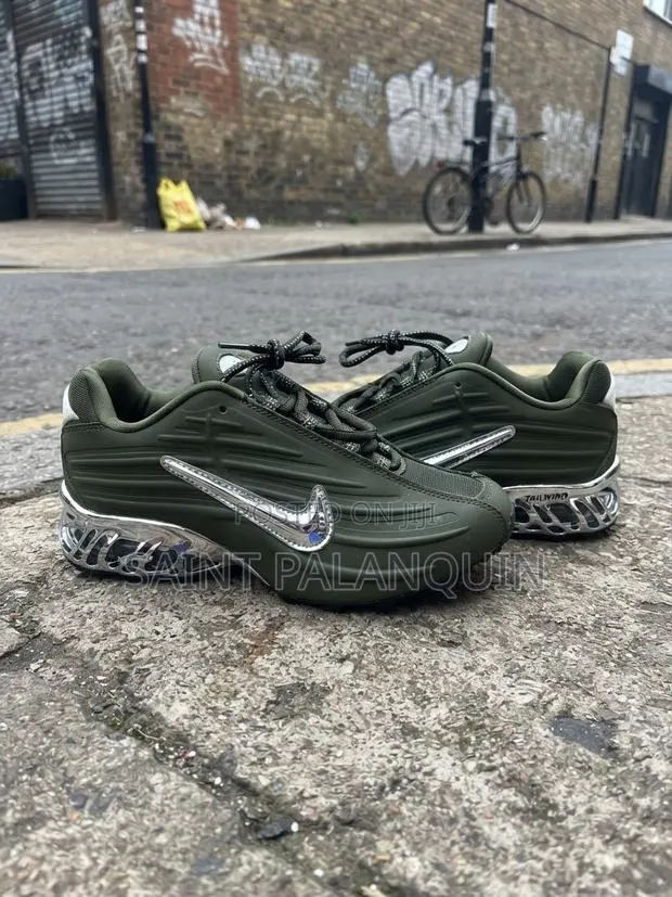 The Image Shows the Olive Green Nike NOCTA Glide Sneakers · Photo 1
